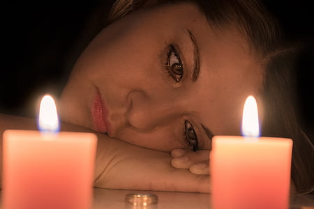 woman near two orange pillar candles thumbnail