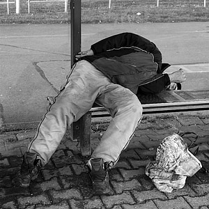grayscale photography of man lying on bench thumbnail