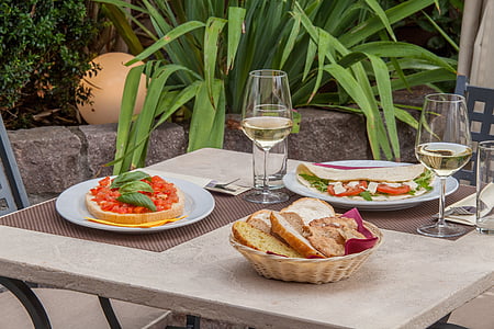 plates with food and basket with breads on table thumbnail