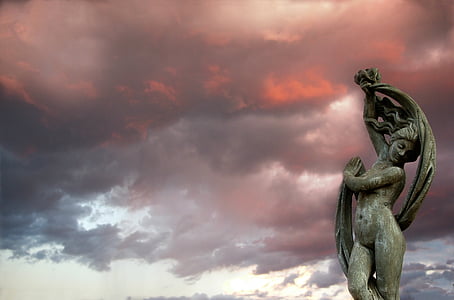woman statue under nimbus clouds thumbnail