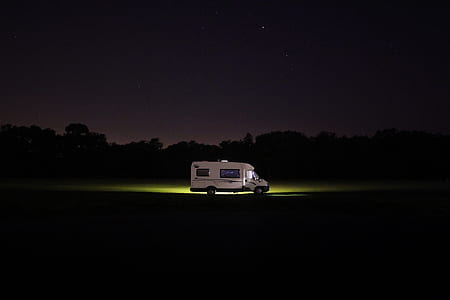 white RV on the road during night time thumbnail
