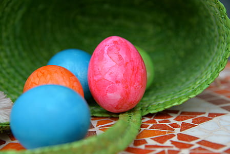 five assorted-color eggs inside green basket thumbnail