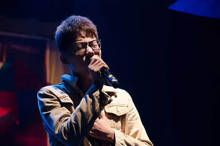 person wearing white dress shirt holding a microphone singing thumbnail