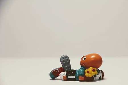orange animal hugging flowers figure on white surface thumbnail