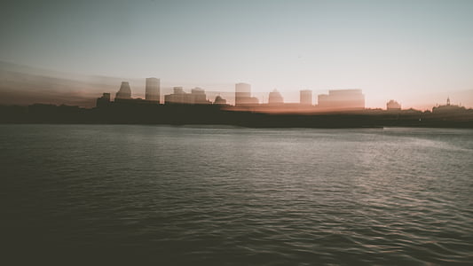 silhouette of buildings near body of water thumbnail