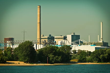 factory building beside body of water thumbnail
