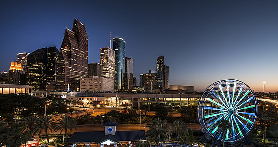 ferris wheel with lights and city buildings in background thumbnail