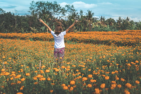 woman standing on green and brown flower plants thumbnail