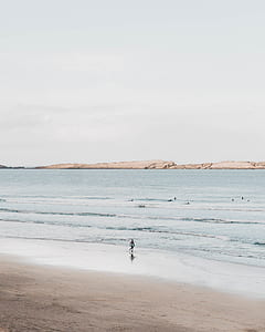 person walking on the beach during daytime thumbnail