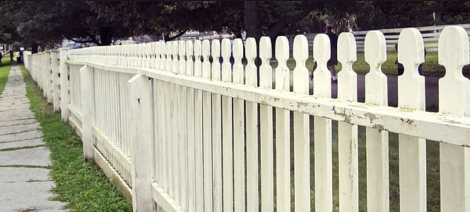 white wooden fence near street during daytime thumbnail