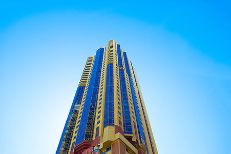 low angle photo of beige and blue high-rise building under blue sky at daytime thumbnail