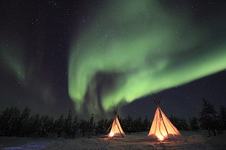 two white tipi tents under aurora lights thumbnail