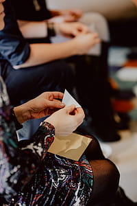 Women folding sheet of paper while making origami thumbnail