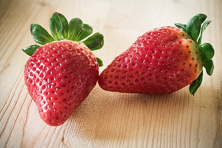 two strawberry fruits on brown wooden surface thumbnail