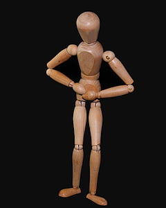 brown wooden puppet standing on black surface thumbnail