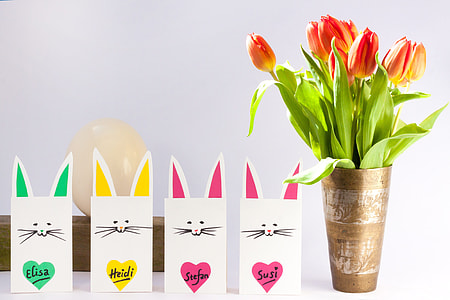 orange and yellow Tulip flowers on vase beside four cats paper bags thumbnail