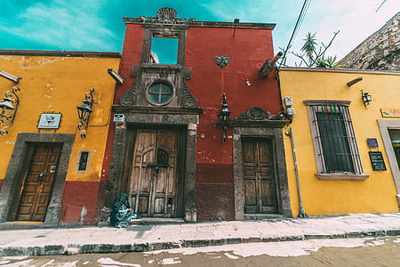red and yellow concrete building under clear blue sky thumbnail