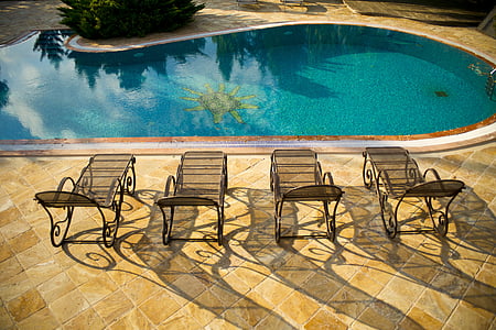 four sunloungers near swimming pool thumbnail