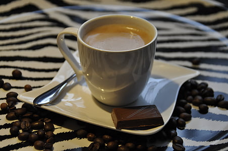 white ceramic cup beside chocolate bar on white ceramic saucer thumbnail