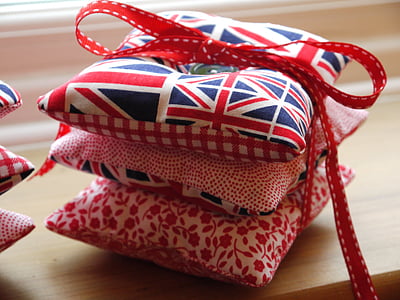 three throw pillows wrap with red ribbon on brown wooden surface thumbnail