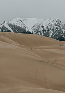 person on desert with glacier mountain painting thumbnail