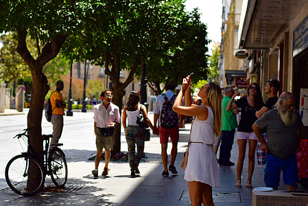 people near building and trees thumbnail