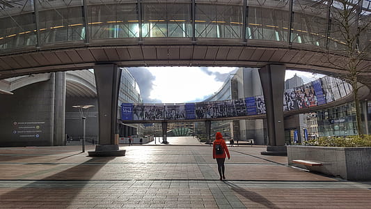 Woman Wearing Hooded Jacket Walking Through Building thumbnail