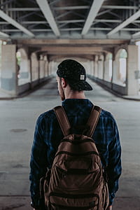 man in blue dress shirt wearing brown backpack thumbnail