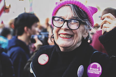 woman smiling while standing beside people at daytime thumbnail