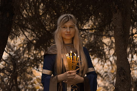 woman holding bundle of lighted candles thumbnail