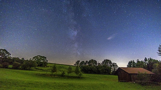 landscape photography of brown house surrounded by green leaf trees under blue sky thumbnail