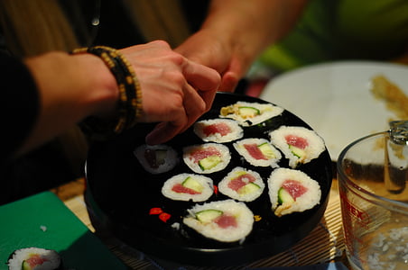 person holding maki rolls thumbnail