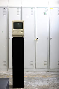 white CRT monitor on black stand near white locker thumbnail