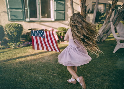 girl holding USA flag while running thumbnail