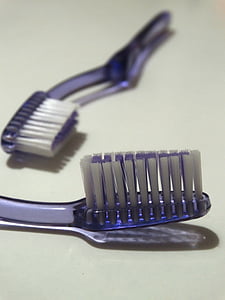 two purple toothbrushes on white surface thumbnail