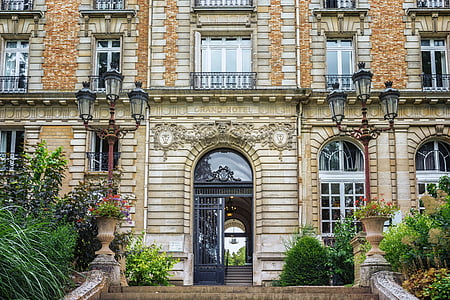 architectural photography of brown brick building with black gate thumbnail