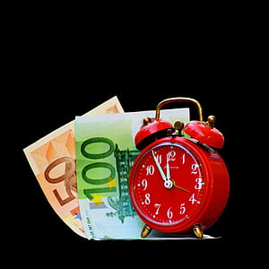 red alarm clock beside banknotes thumbnail