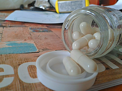 white medication pills inside clear glass jar thumbnail