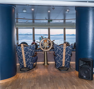 two blue armchairs in front of gray shipwheel thumbnail