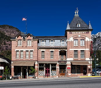 brown concrete building near mountains thumbnail
