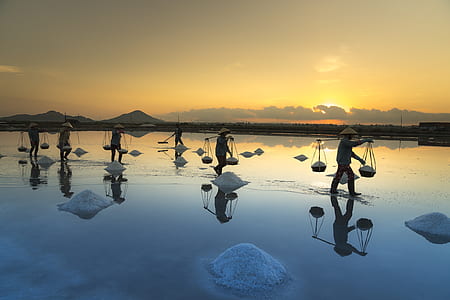 men wearing brown hat standing on body of water thumbnail