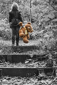 selective color photography of woman holding brown bear plush toy thumbnail