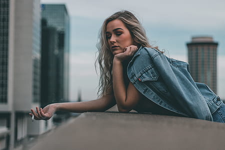 woman leaning on wall during daytime thumbnail