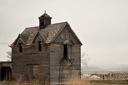 brown wooden 2-storey house in the middle of brown field thumbnail