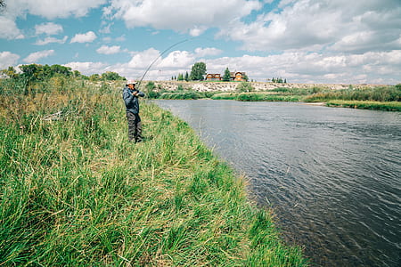 man fishing near body of water taken at daytime thumbnail