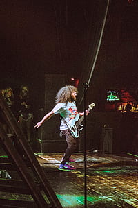man singing while using electric guitar on stage thumbnail