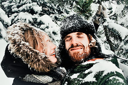 woman in duffle coat beside man during snowtime thumbnail
