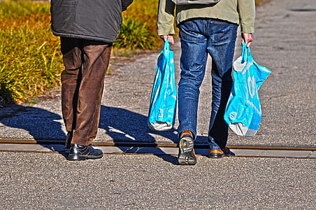 person carrying blue plastic bags thumbnail