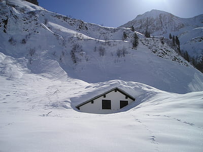 house under snow in front of alp photo thumbnail