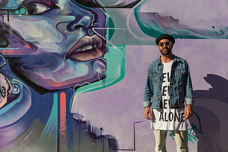 Urban portrait of a man standing by vibrant street art in London, England. Image captured with a Canon 6D thumbnail